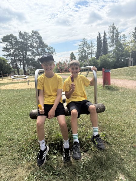 Erschöpfte, aber lachende Schüler genießen nach dem Sportfest eine eisige Belohnung im Freien.