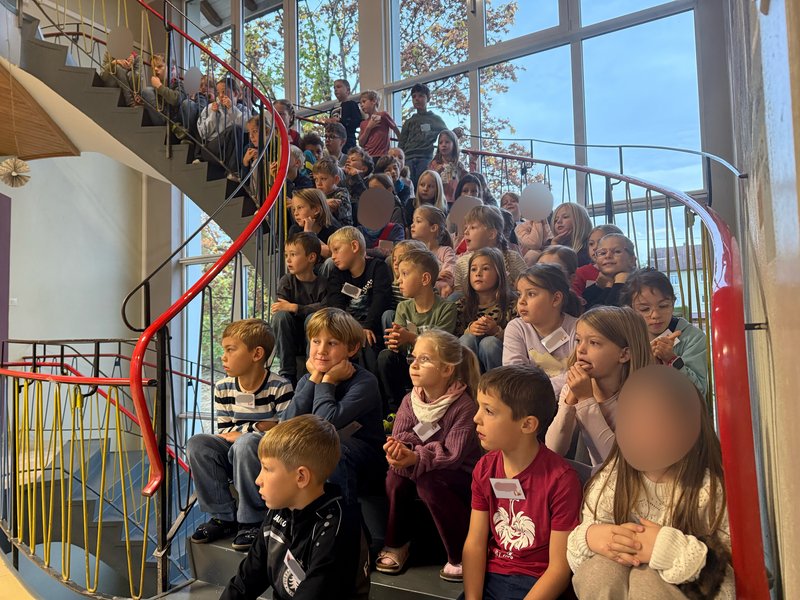 Die Schülerinnen und Schüler der Grundschule Tannheim lauschen einem musikalischen Vortrag der Musikkapelle.