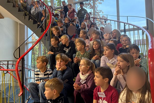 Die Schülerinnen und Schüler der Grundschule Tannheim lauschen einem musikalischen Vortrag der Musikkapelle.