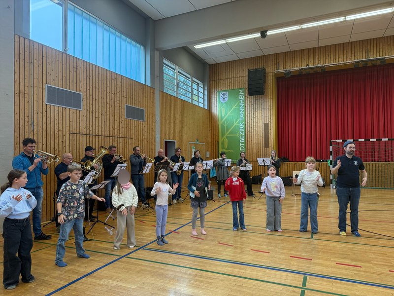 Die Schülerinnen und Schüler führen den zuvor einstudierten Tanz vor, den die Musikkapelle Tannheim musikalisch begleitet.