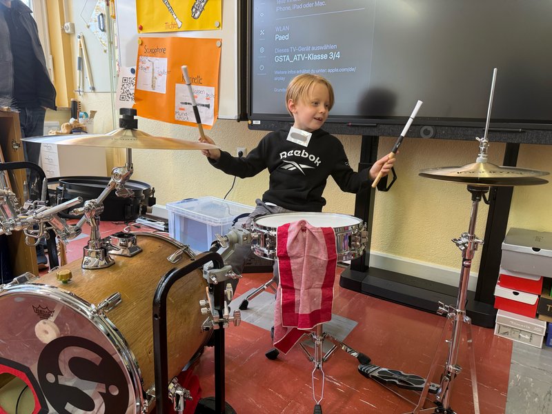 Ein Schüler probiert das Instrument "Schlagzeug" aus.