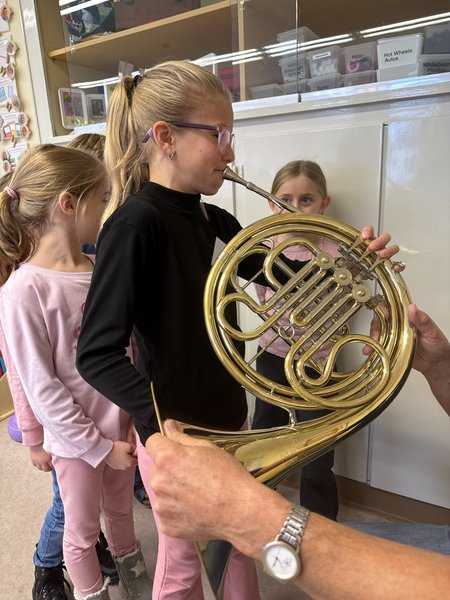 Eine Schülerin probiert das Instrument "Horn" aus.
