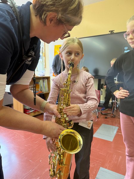 Eine Schülerin probiert das Instrument "Saxophon" aus.