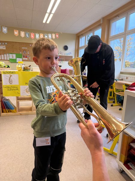 Ein Schüler probiert das Instrument "Trompete" aus.